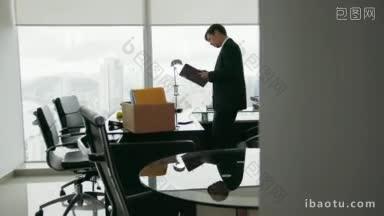 一个最近被公司录用的商人搬进了他的新办公室，他拿出一个文件夹，阅读附近的文件